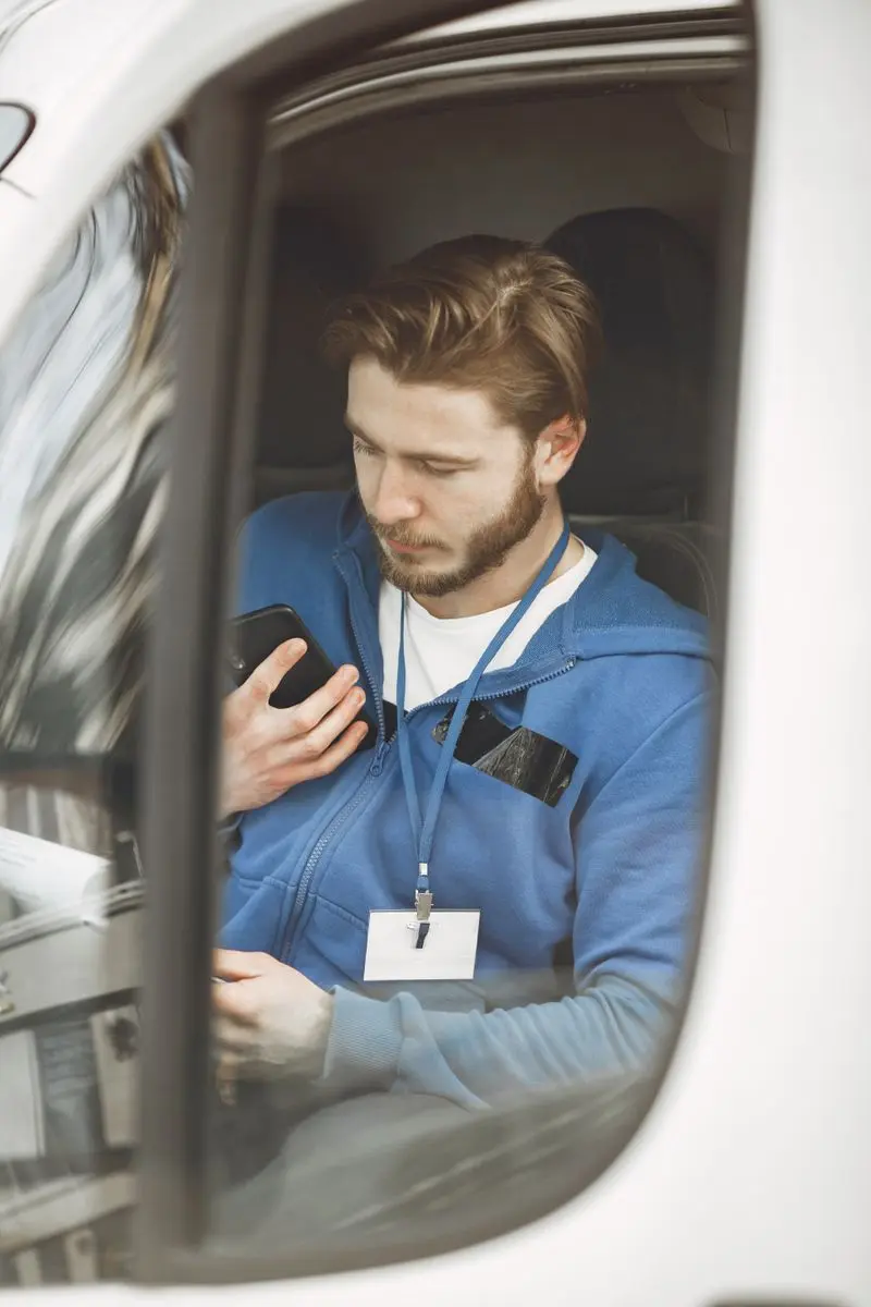 Delivery driver checking the next stop from inside a van